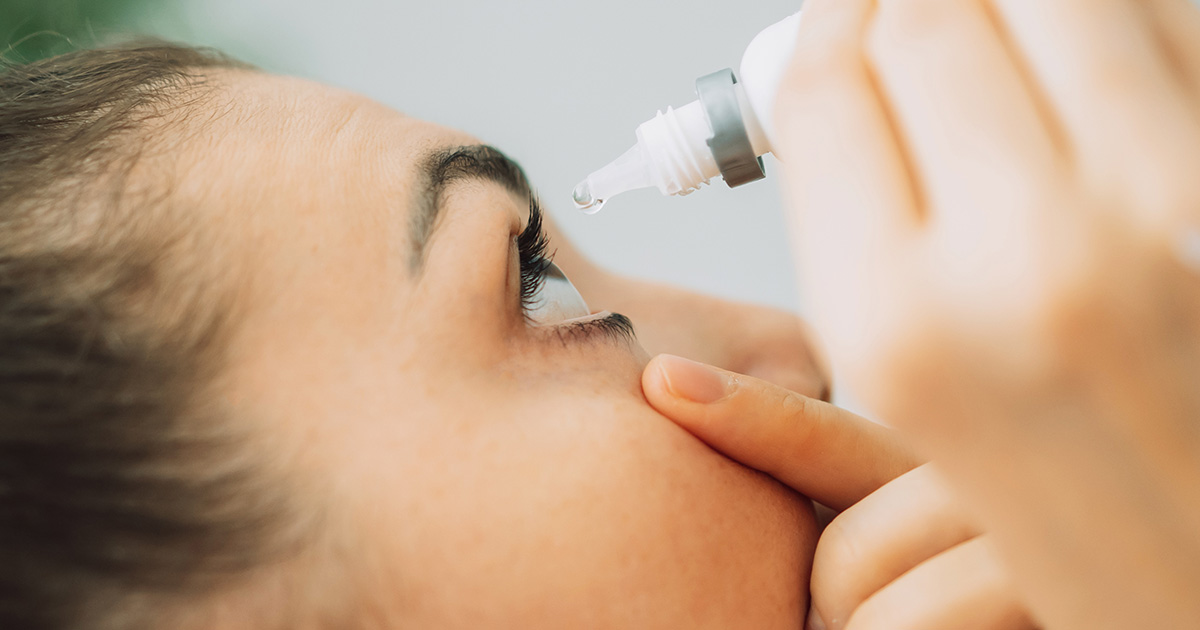 Patientin tropft sich die Augen nach dem Augenlasereingriff